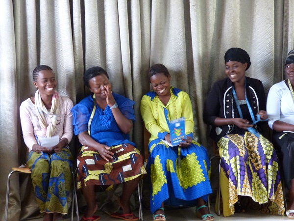 Young women wearing bright Aftican print fabrics sit together after a music therapy session at the Panzi Hospital in the Democratic Republic of Congo.
