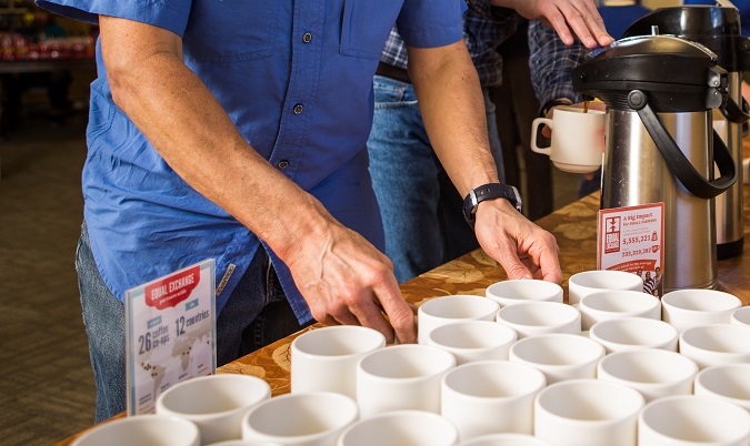 At church, a volunteer lines up cups to be filled with organic coffee.