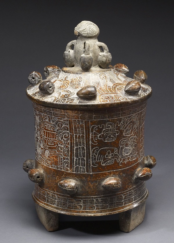 This Maya lidded figure is ringed by molded cacao pods and has pictures that are difficult to make out etched into the side. The knob os a cacao tree.