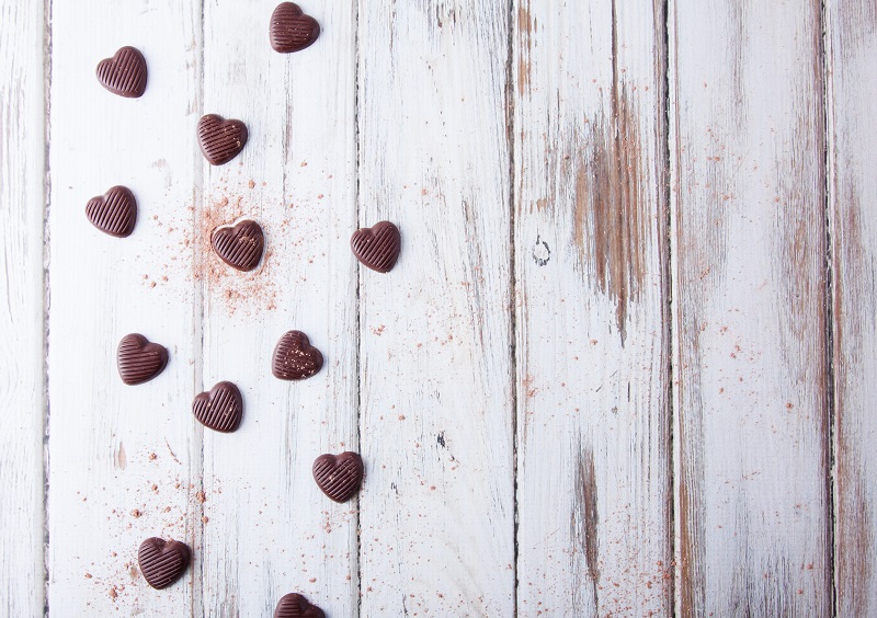Heart shaped chocolates on a background of white boards, made with chocolate molds.