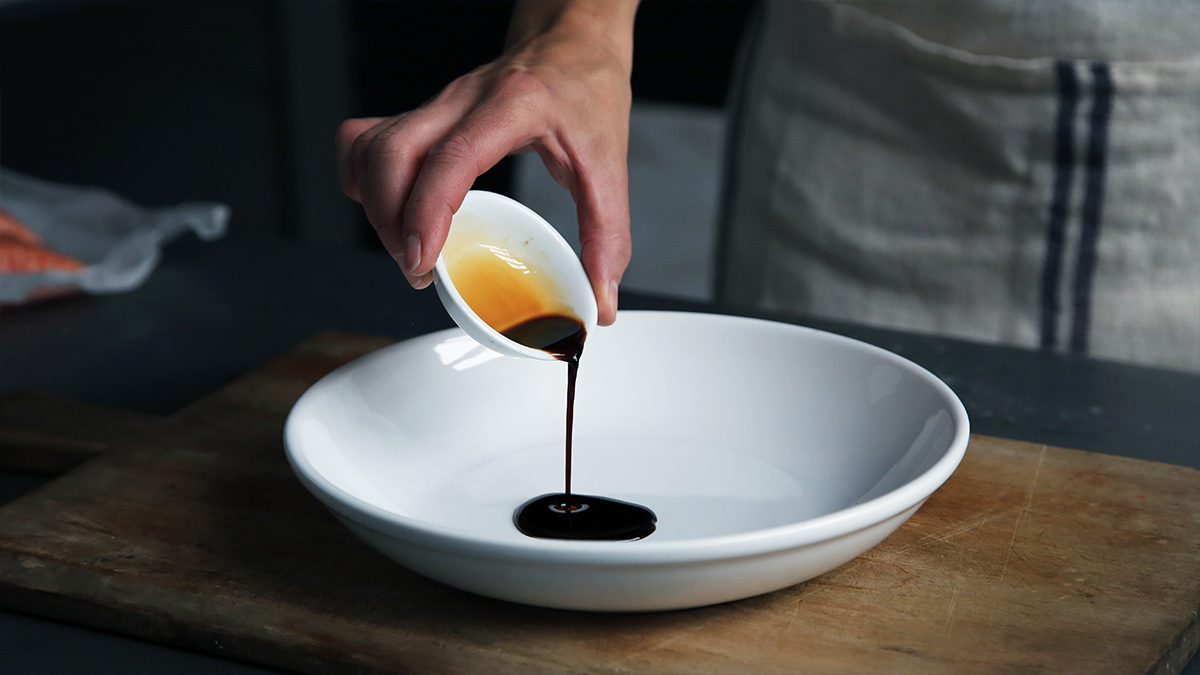 Pouring vinegar into a bowl for salad dressing