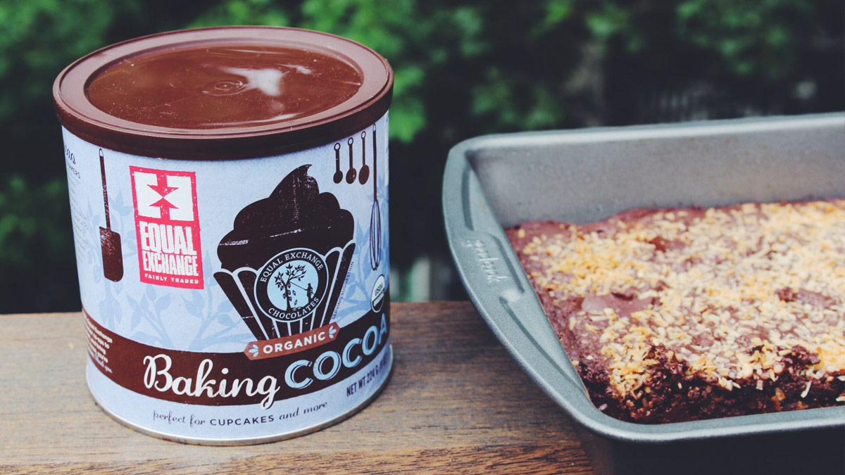 tray of dark chocolate coconut brownies next to a can of baking cocoa