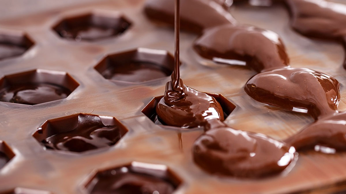 Pouring melted chocolate into molds
