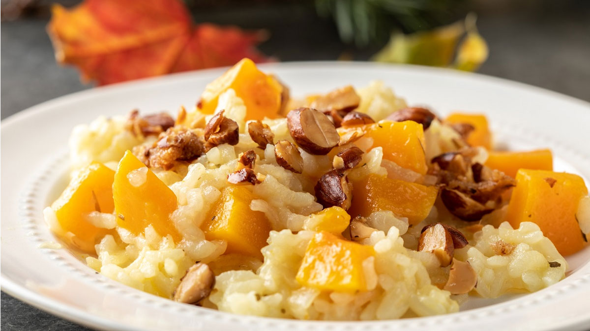 a plate of risotto with chuncks of butternut squash, topped with almonds