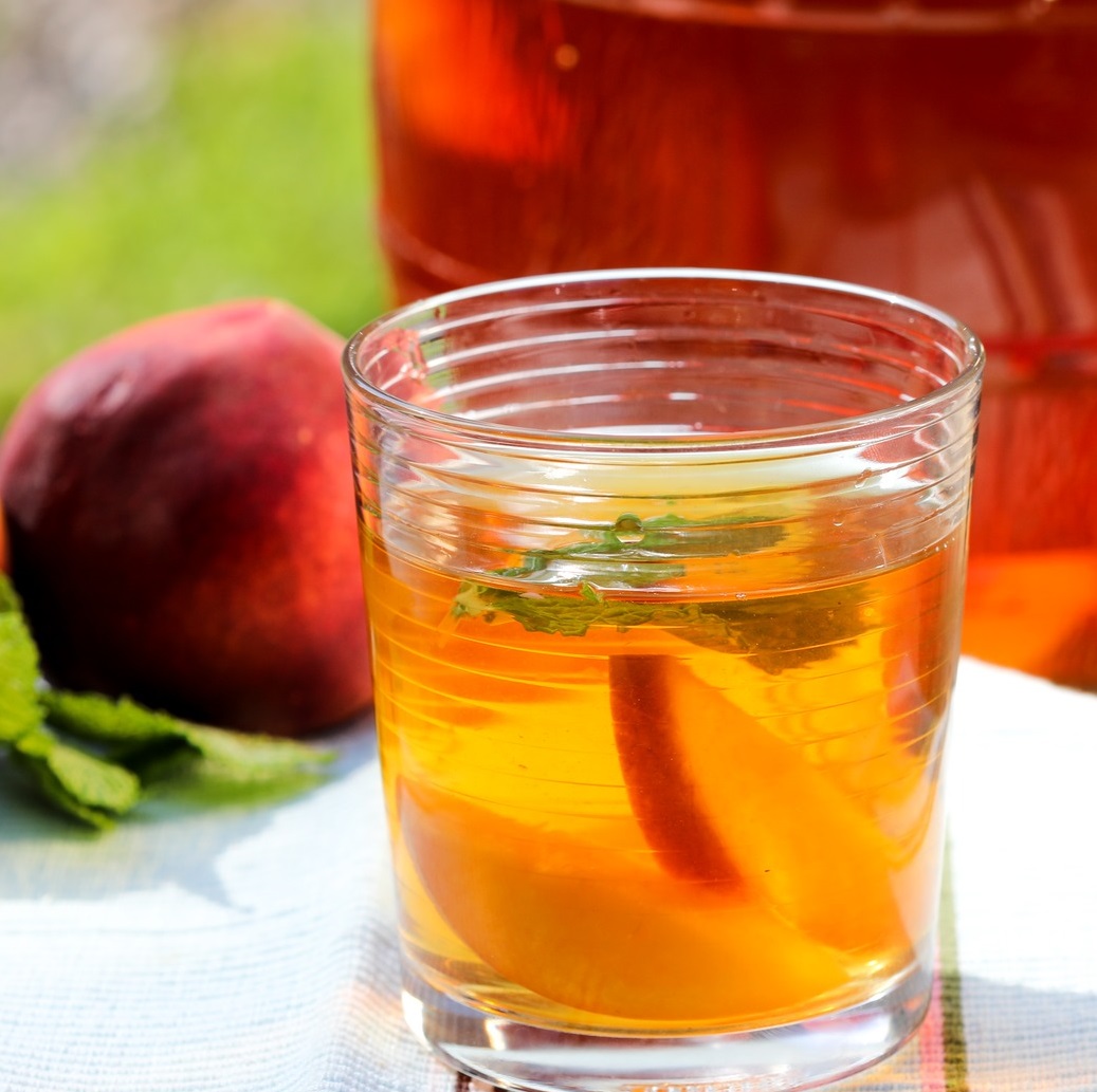 A glass of tea with peaches
