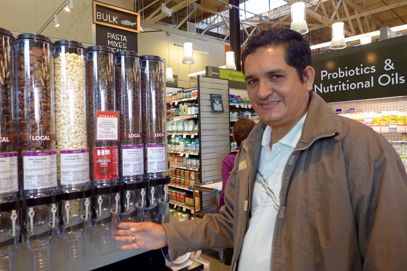 A man stands in front of bulk bins at a co-op