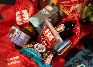 a fair trade basket full of baking treats like chocolate chips, olive oil, baking cocoa, tea and almonds