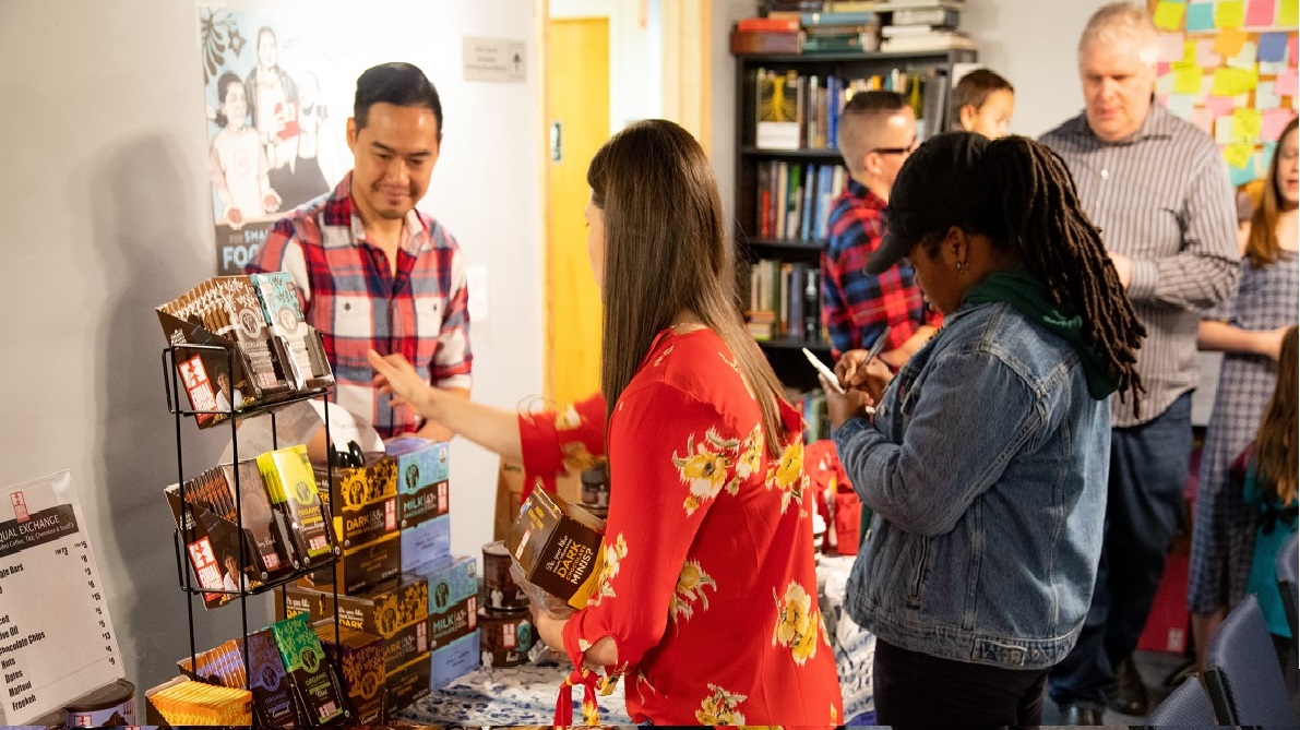 shoppers choose fair trade items at a table sale
