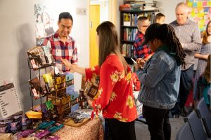 shoppers selecting fair trade items at a table sale