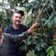 Todd with coffee plant and farmer